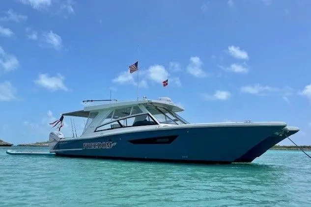 The Image of 2021 World Cat 400 DC-X boat on clear turquoise water under a blue sky. - 0