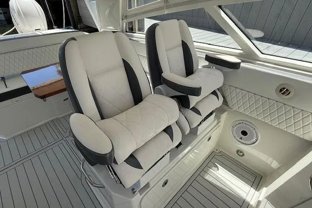Slide: The Image of Luxurious seating in 2021 World Cat 400 DC-X boat interior, featuring plush white and gray upholstery. - 11