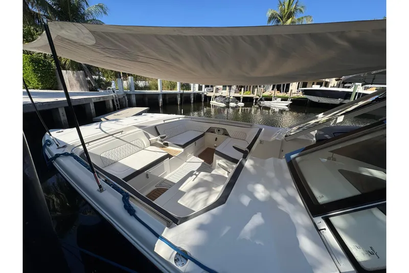 Slide: The Image of 2021 World Cat 400 DC-X boat with shaded seating area docked by the water. - 17