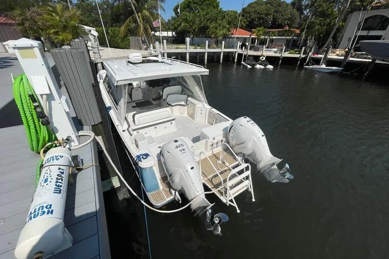 Slide: The Image of 2021 World Cat 400 DC-X boat docked with twin engines, in a serene marina setting. - 24