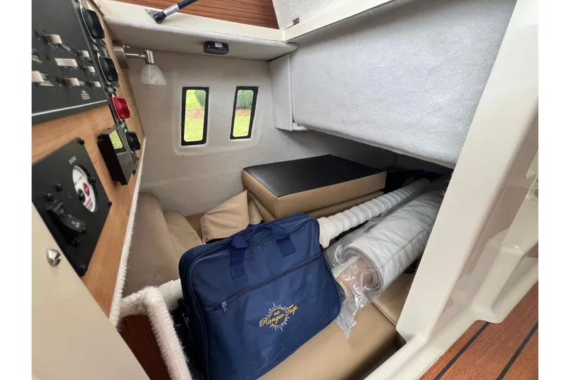 Slide: The Image of 2025 Ranger Tugs R-25 cabin interior with control panel and storage area. - 15