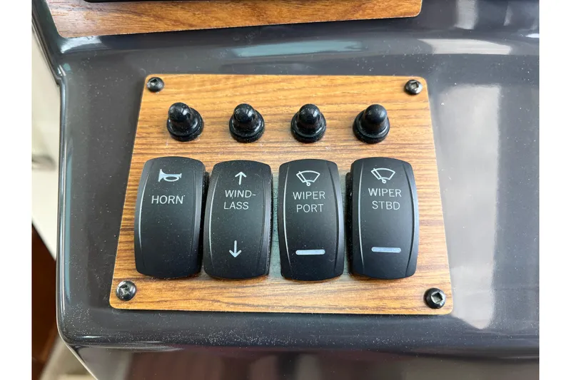 Slide: The Image of Control panel of 2025 Ranger Tugs R-25 with switches for horn, windlass, and wipers. - 20
