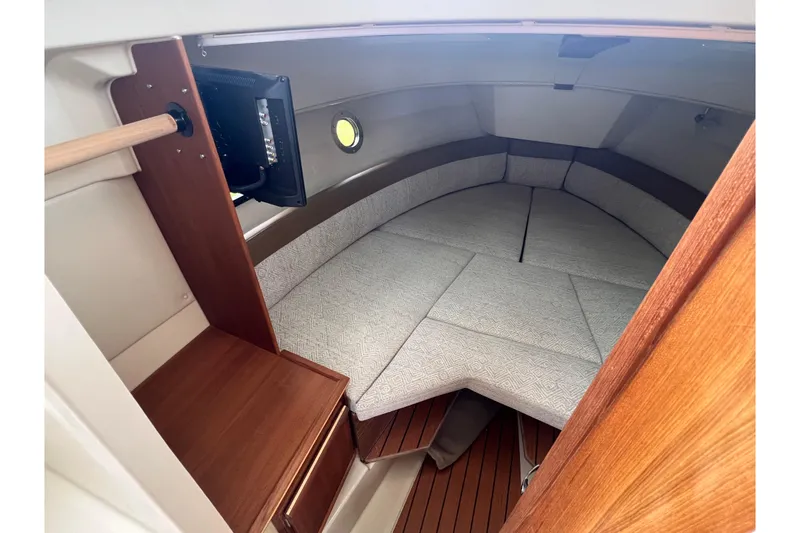 Slide: The Image of 2025 Ranger Tugs R-25 cabin interior with cozy seating and wooden accents. - 22