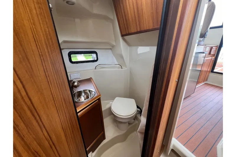 Slide: The Image of 2025 Ranger Tugs R-25 boat interior bathroom with sink and toilet. - 25