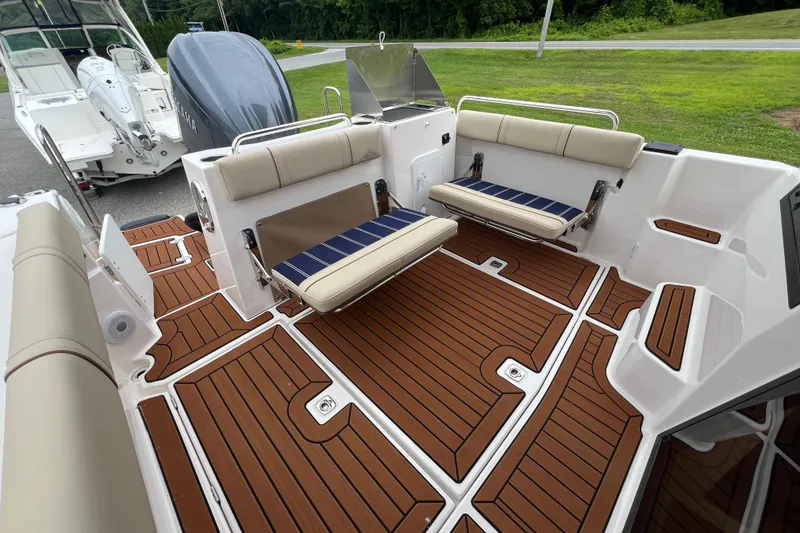 Slide: The Image of 2025 Ranger Tugs R-25 boat interior with foldable seats and teak-style flooring. - 7