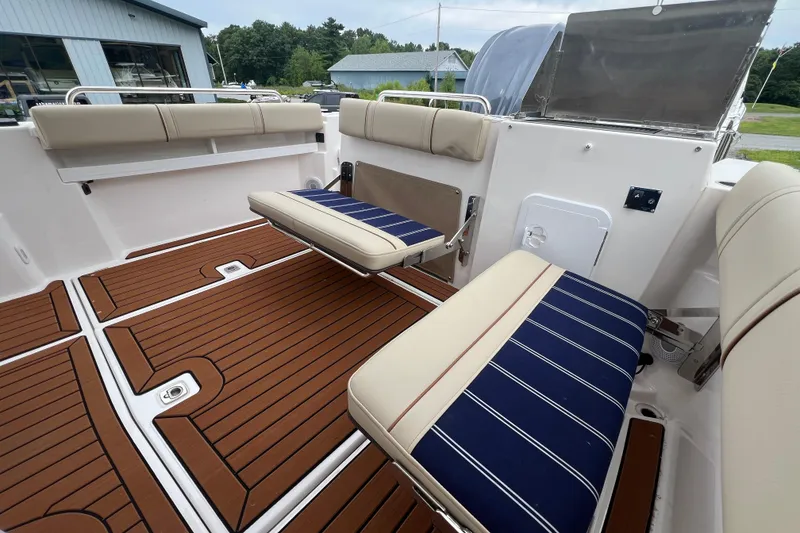 Slide: The Image of 2025 Ranger Tugs R-25 boat interior with striped seating and teak-style flooring. - 9