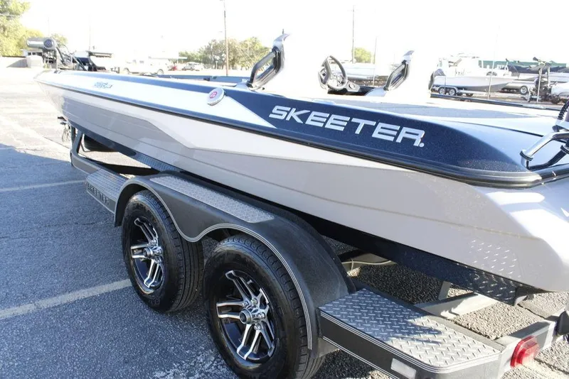 Slide: The Image of 2023 Skeeter ZXR21 boat on trailer, showcasing sleek design and dual wheels. - 17