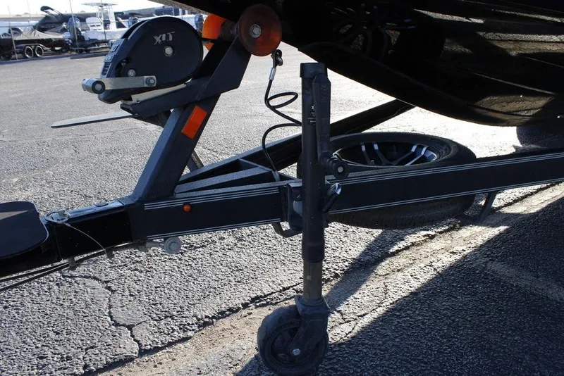 Slide: The Image of Trailer hitch and wheel assembly of 2023 Skeeter ZXR21 boat on asphalt surface. - 19