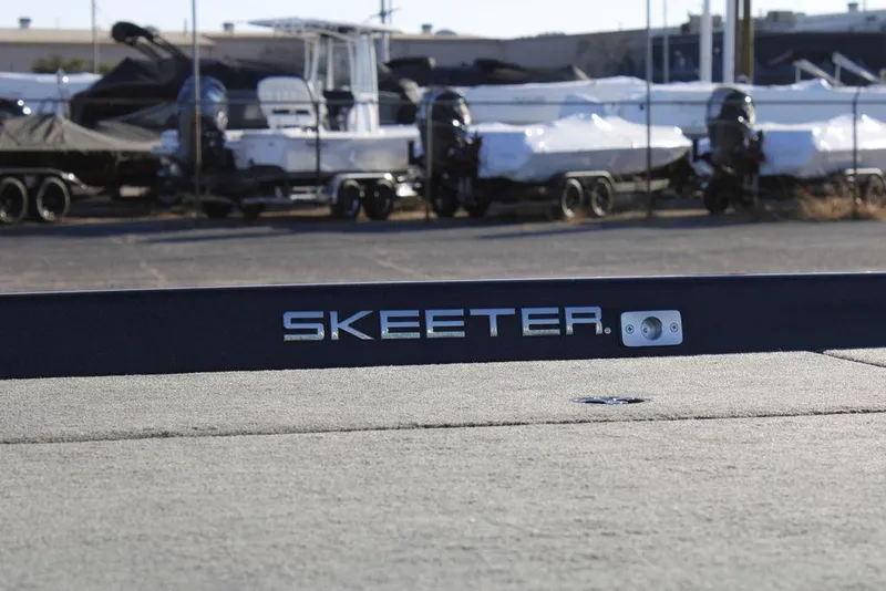 Slide: The Image of 2023 Skeeter ZXR21 boat in a marina with covered boats in the background. - 22