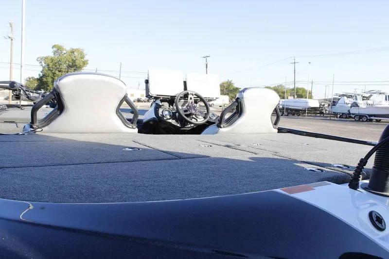 Slide: The Image of 2023 Skeeter ZXR21 boat interior with steering wheel and seating, parked outdoors. - 24