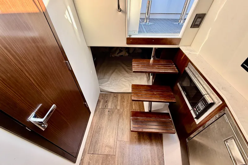 Slide: The Image of 2022 New Cruiser Yachts GLS 38 helm with modern controls, steering wheel, and waterfront view. - 33