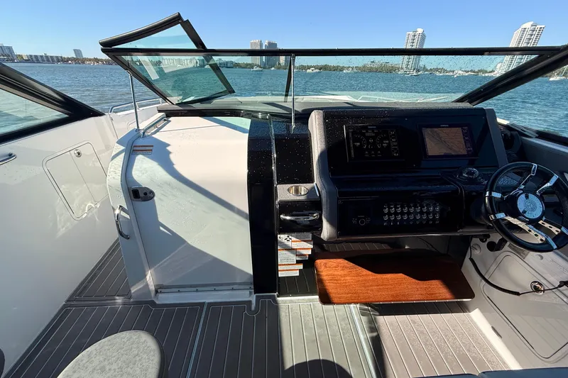 Slide: The Image of 2022 New Cruiser Yachts GLS 38 helm with modern controls, steering wheel, and waterfront view. - 25