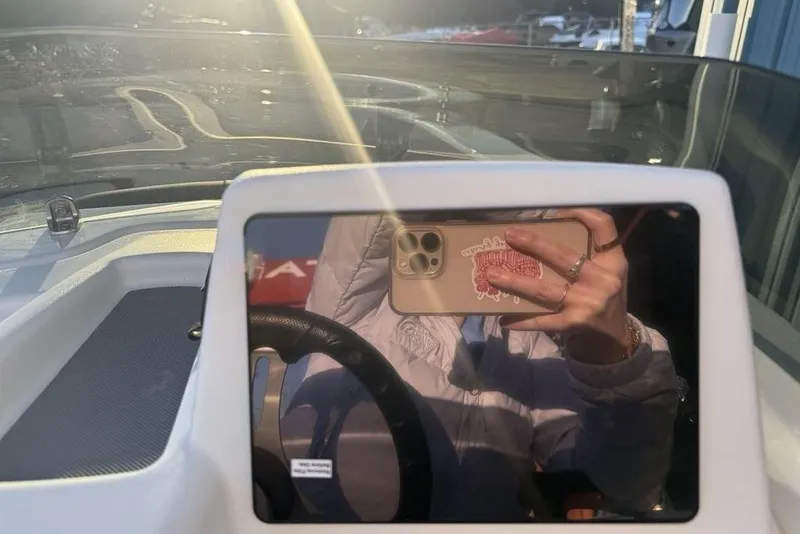 Slide: The Image of Reflection on Tahoe T16 boat dashboard, 2026 model, with smartphone in hand. - 17