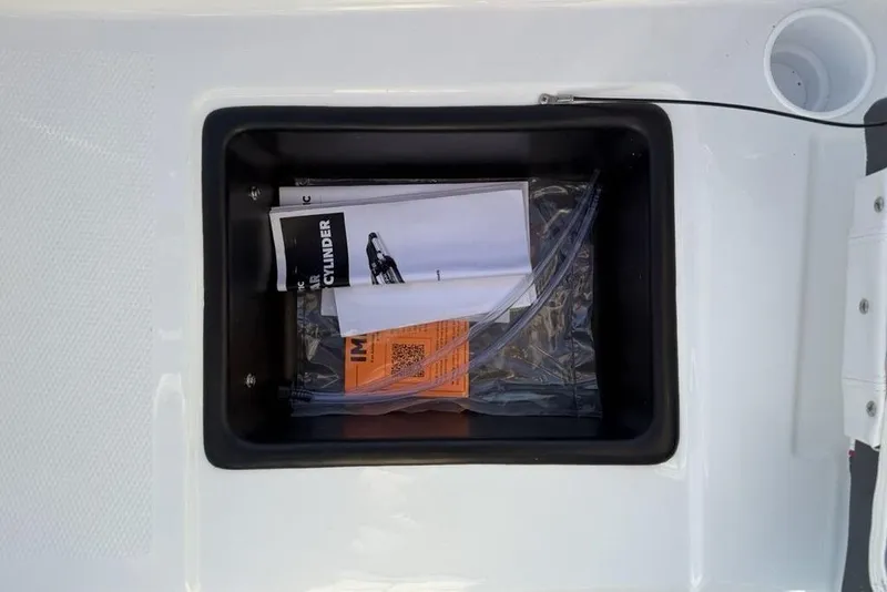 Slide: The Image of Storage compartment of 2026 Tahoe T16 boat with manuals and documents. - 26