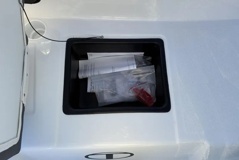 Slide: The Image of Open storage compartment in 2026 Tahoe T16 boat with documents and accessories. - 28