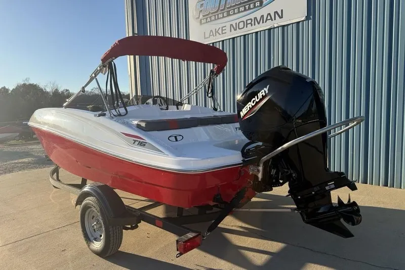 Slide: The Image of 2026 Tahoe T16 boat with Mercury engine, red and white design, parked at Lake Norman. - 6