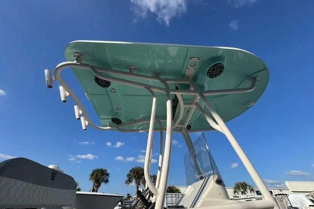 Slide: The Image of 2024 Carolina Skiff 24 Ultra Elite boat with T-top under a clear blue sky. - 10