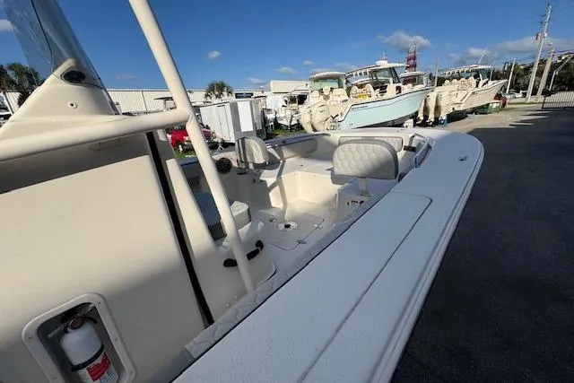 Slide: The Image of 2024 Carolina Skiff 24 Ultra Elite boat, spacious deck, parked outdoors under clear blue sky. - 9