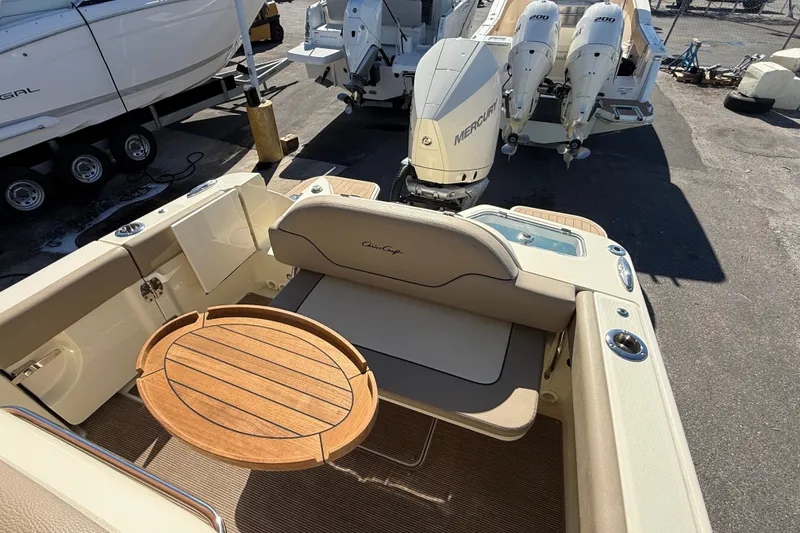 Slide: The Image of 2023 Chris-Craft Catalina 24 boat interior with wooden table and Mercury engines. - 11