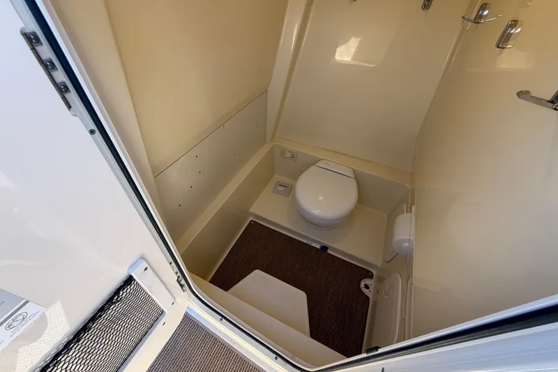 Slide: The Image of 2023 Chris-Craft Catalina 24 boat bathroom interior with toilet and beige walls. - 14
