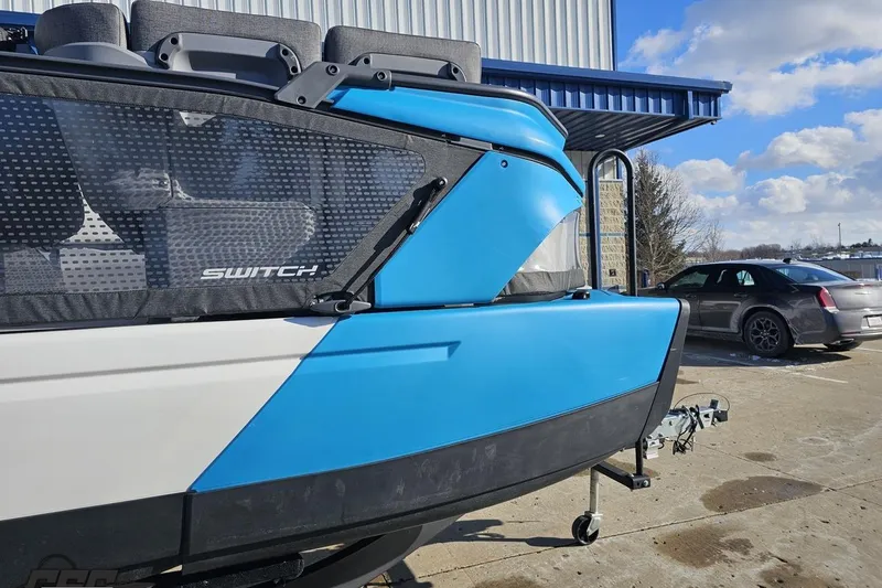 Slide: The Image of 2023 Sea-Doo Switch Cruise 21 boat, blue and white exterior, parked outdoors. - 13