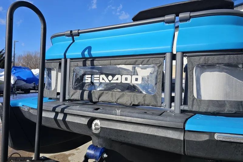 Slide: The Image of 2023 Sea-Doo Switch Cruise 21, blue exterior, rear view with logo, sunny day. - 19