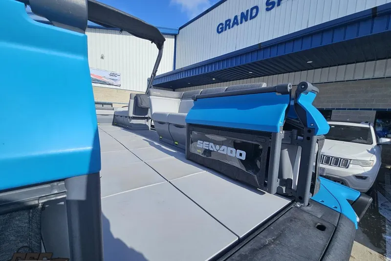 Slide: The Image of 2023 Sea-Doo Switch Cruise 21 pontoon boat at dealership, showcasing deck and seating. - 21