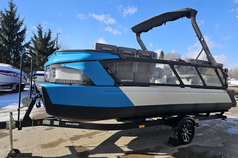 Slide: The Image of 2023 Sea-Doo Switch Cruise 21 pontoon boat on trailer, blue and black design. - 25