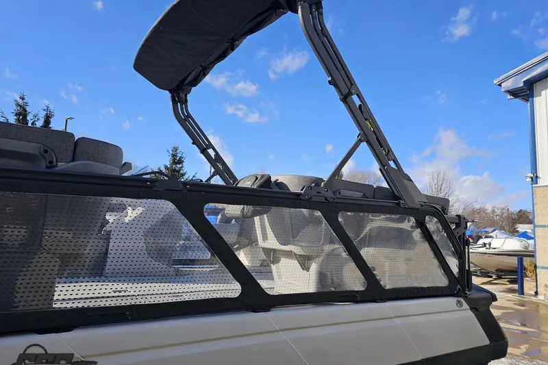Slide: The Image of 2023 Sea-Doo Switch Cruise 21 pontoon boat with canopy, parked outdoors under blue sky. - 28