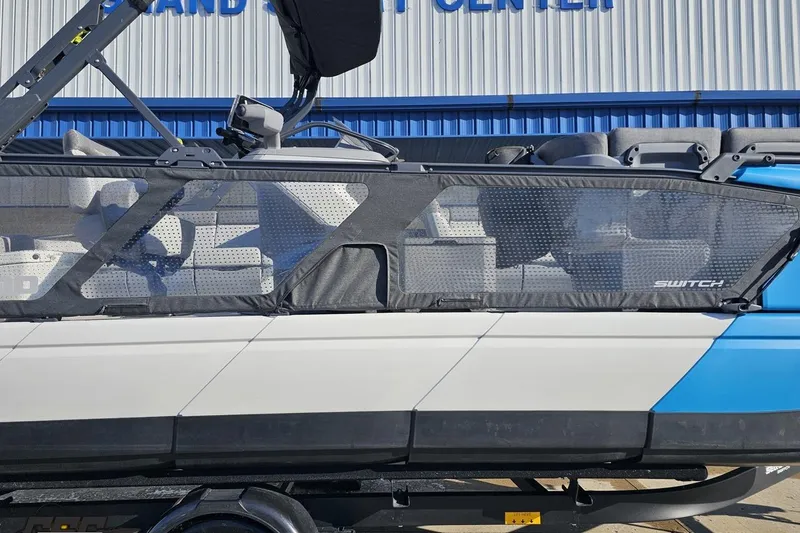 Slide: The Image of 2023 Sea-Doo Switch Cruise 21 pontoon boat, side view, blue and white design. - 3