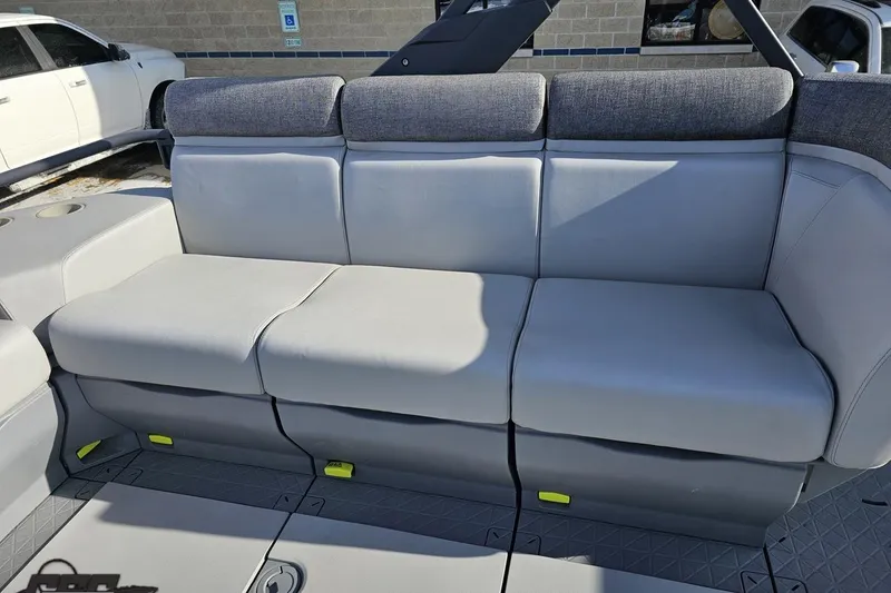 Slide: The Image of 2023 Sea-Doo Switch Cruise 21 boat seating, featuring gray cushioned seats and cup holders. - 57