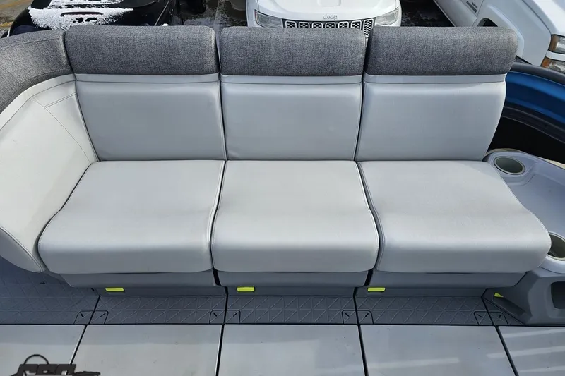 Slide: The Image of 2023 Sea-Doo Switch Cruise 21 boat seating with gray upholstery and cup holders. - 92