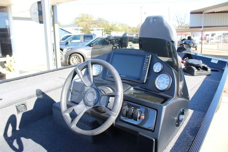 Slide: The Image of 2023 Lowe Skorpion 17 boat dashboard with steering wheel and digital display. - 11