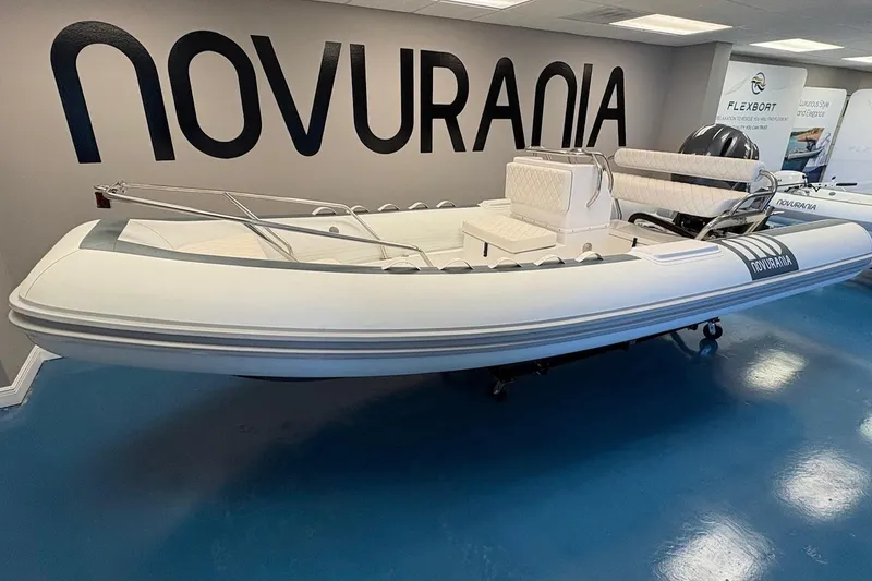 Slide: The Image of 2025 Novurania DL 550 boat with Yamaha 115, displayed indoors with promotional signage. - 1