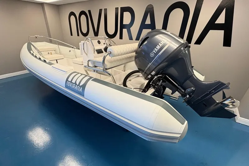 Slide: The Image of 2025 Novurania DL 550 boat with Yamaha 115 engine displayed indoors. - 2