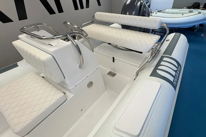 Slide: The Image of 2025 Novurania DL 550 boat with Yamaha 115, displayed indoors on blue floor. - 4