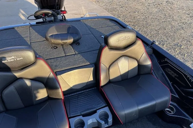 Slide: The Image of 2023 Skeeter ZX200 boat interior with black and red seats, cup holders, and storage compartments. - 18