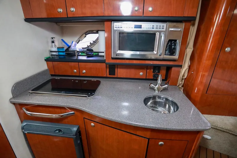 Slide: The Image of 2007 Sea Ray Sundancer 310 galley with microwave, sink, and stove. - 15