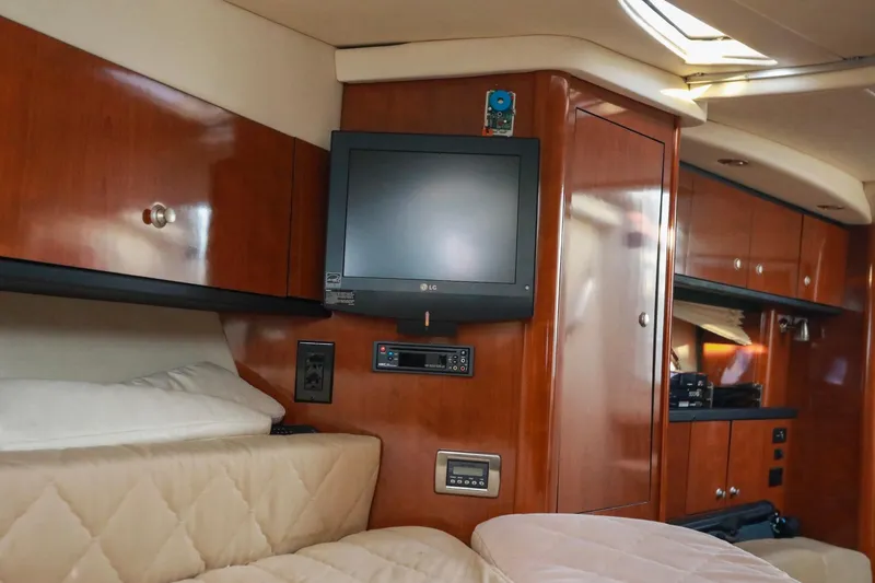 Slide: The Image of Interior of 2007 Sea Ray Sundancer 310 with TV, wood cabinets, and beige seating. - 18