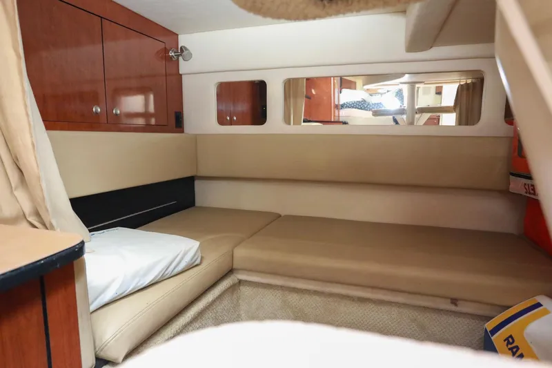 Slide: The Image of 2007 Sea Ray Sundancer 310 cabin interior with beige seating and wooden cabinetry. - 19