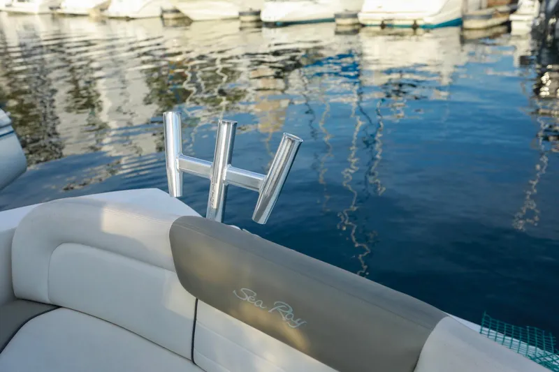 Slide: The Image of 2007 Sea Ray Sundancer 310 boat interior with rod holders, docked on calm water. - 25