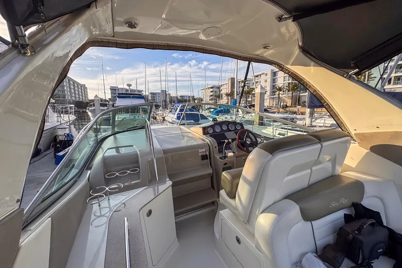 Slide: The Image of 2007 Sea Ray Sundancer 310 interior view at marina, showcasing helm and seating area. - 5