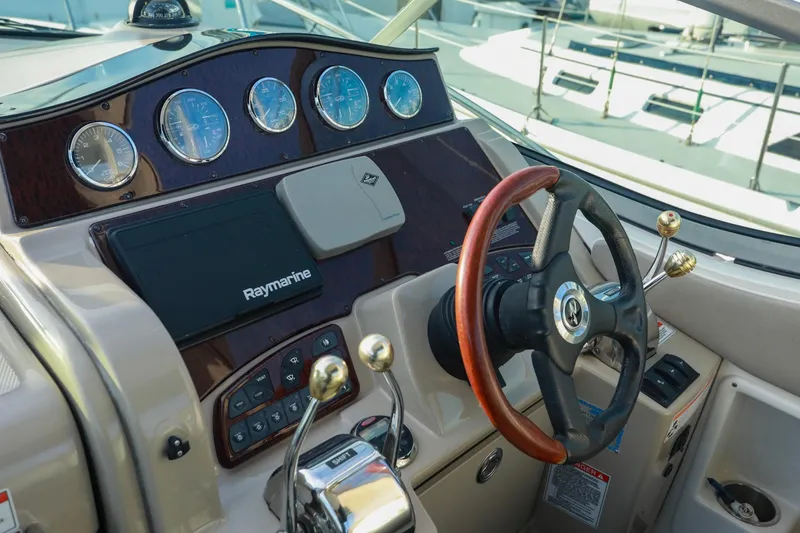 Slide: The Image of 2007 Sea Ray Sundancer 310 helm with Raymarine navigation, gauges, and wooden steering wheel. - 7