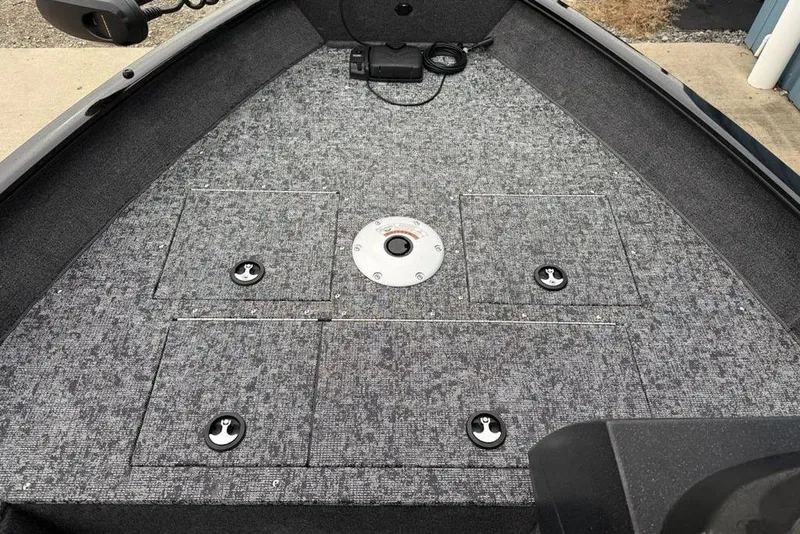 Slide: The Image of 2026 Tracker Pro Guide V-16 SC boat deck with storage compartments and carpeted surface. - 10