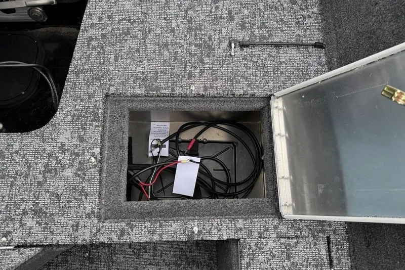 Slide: The Image of Storage compartment in 2026 Tracker Pro Guide V-16 SC boat, featuring cables and organized interior. - 22