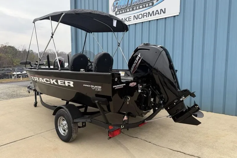 Slide: The Image of 2026 Tracker Pro Guide V-16 SC boat with Mercury engine, parked outside marine center. - 3