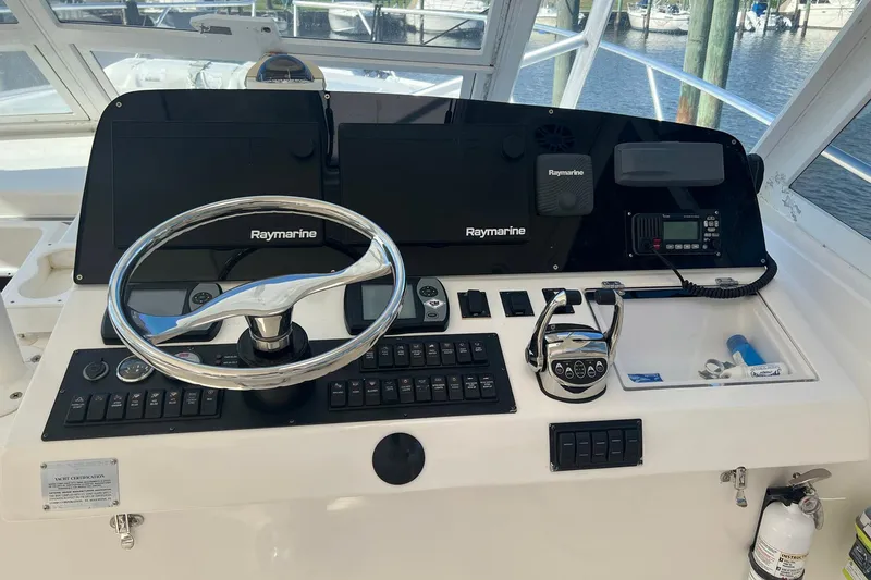 Slide: The Image of 2007 Luhrs 41 Hardtop helm with Raymarine electronics and steering wheel. - 17