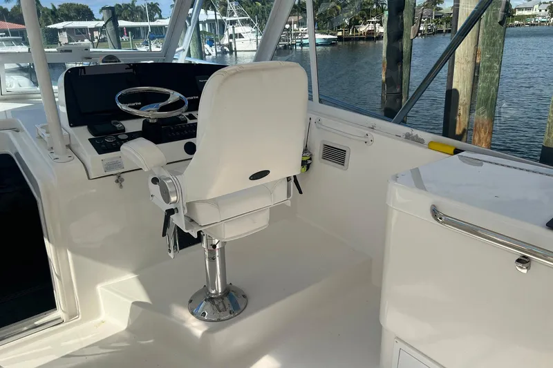 Slide: The Image of 2007 Luhrs 41 Hardtop boat helm with white captain's chair and steering wheel. - 19