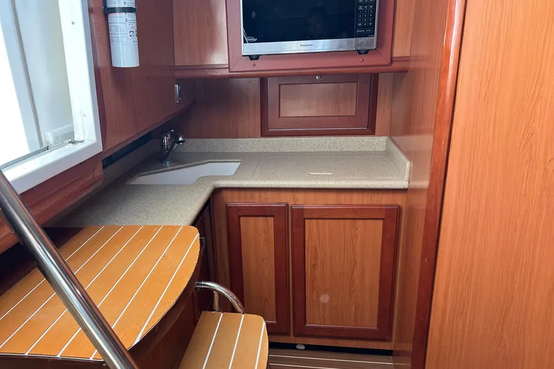 Slide: The Image of 2007 Luhrs 41 Hardtop yacht interior kitchen with wood cabinetry and microwave. - 5