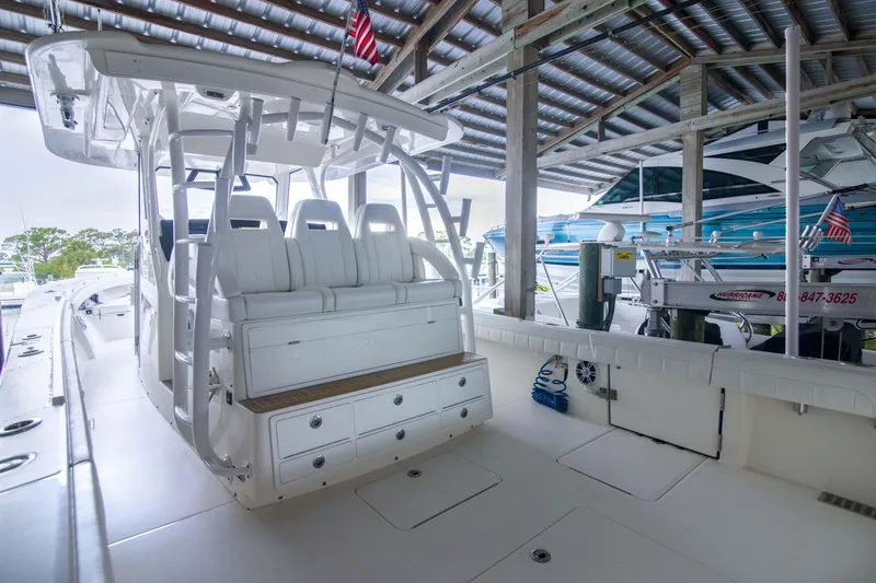 Slide: The Image of 2021 Regulator 41 boat interior with white seating and storage, docked under a covered area. - 11